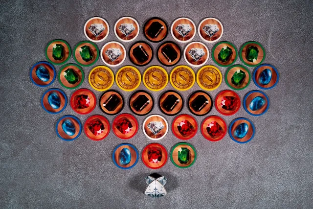 Gem tokens arranged in a fan: white diamonds, blue sapphires, green emeralds, red rubies, black onyx and gold