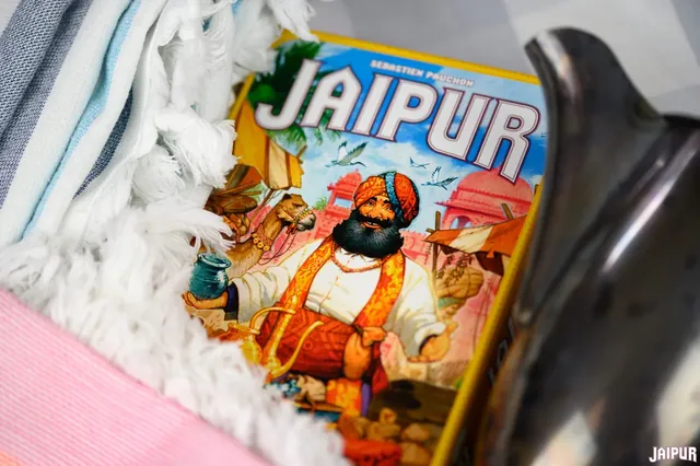 The Jaipur box lying on a soft rug next to a silver pot