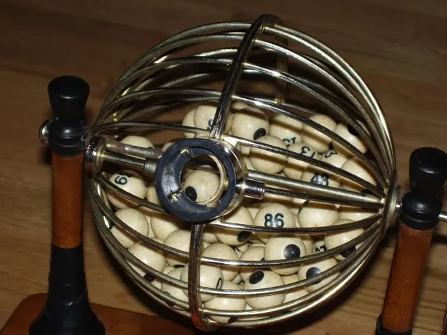 A brass wire ball cage on a stand, used to draw numbered balls