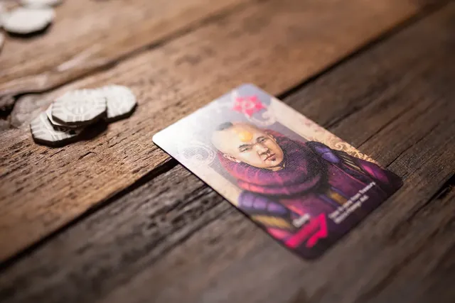 A character card and silver coins on a wooden table