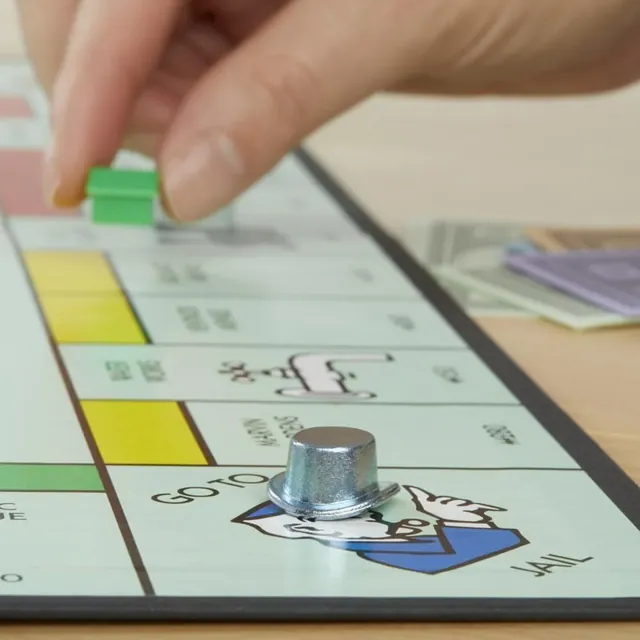 A player places a green house on the Monopoly board