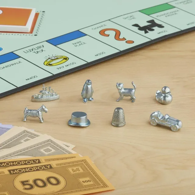 Eight Monopoly tokens beside the board