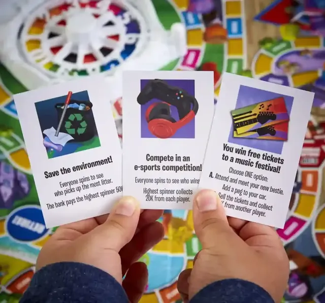 A hand holding three Action cards over the board
