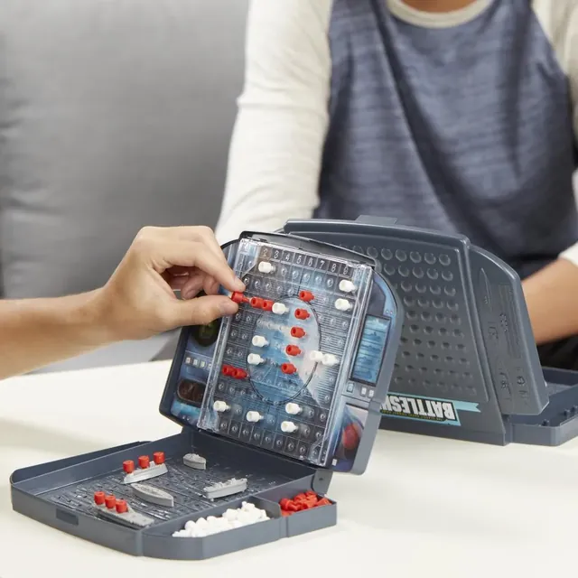 A player pushing a peg into the target grid of a grey battle case