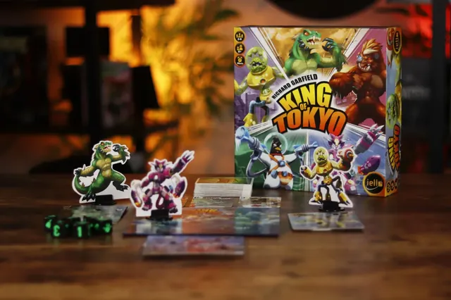 Monster figures, dice and energy cubes in front of the King of Tokyo box
