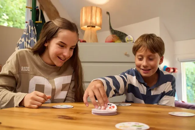 Two children racing to spot the matching symbol between their cards