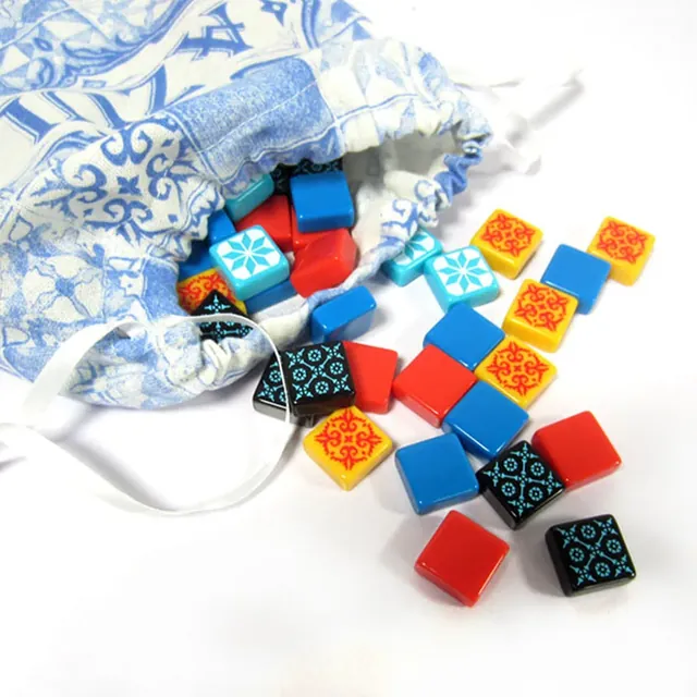 The cloth tile bag spilling blue, red, yellow, black and pale blue tiles