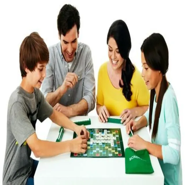A family of four leaning over a green Scrabble board, placing tiles